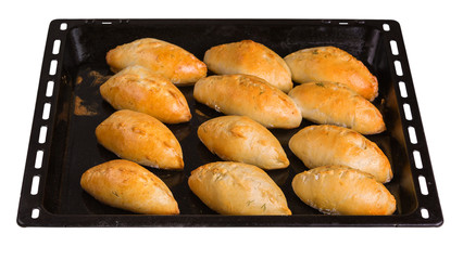 Freshly baked pies lying on a black steel baking sheet
