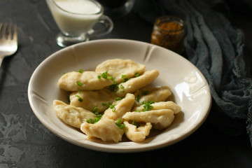 dumplings in a white plate (stuffing dough, different fillings). food background. dark background. top
