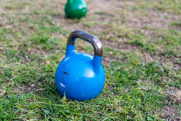 Fototapeta na wymiar Kettlebell on the lawn for outdoor strength exercise.