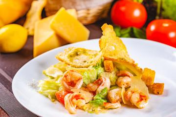 Caesar salad with shrimps on white plate