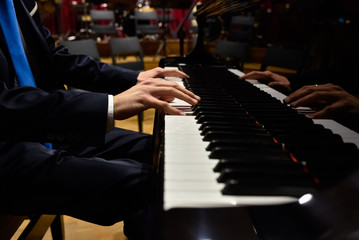 Male pianist playing classical music on a grand piano.