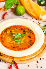 Vegetable soup with herbs and spices in white plate