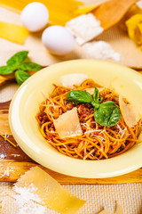 Spaghetti bolognese with minced meat and parmesan cheese in beige plate