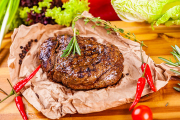 Grilled meat with spices and herbs  on wooden board