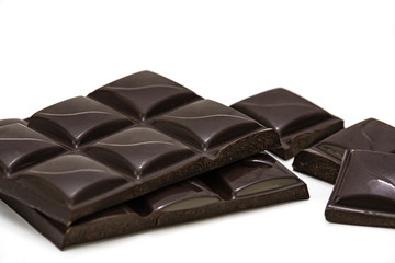 Pieces of premium dark chocolate isolated on white a background in close-up