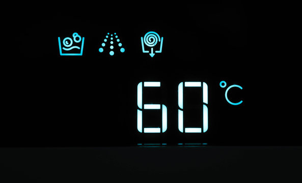 Washing machine panel display, setting 60 degrees temperature. Abstract hot water laundry programming backdrop, closeup.
