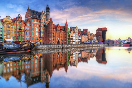 Gdansk with old town and port crane reflected in Motlawa river at sunrise, Poland.
