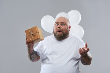 Surprised man holding lovely present and opening his mouth