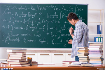 Young male student studying math at school