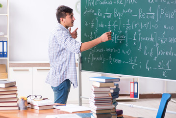 Young male student studying math at school