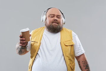 Relaxed bearded man enjoying the music in his headphones