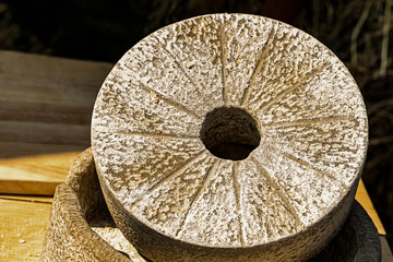gray stone round wooden old groove lines traditional way of grinding seed grains making porridge...
