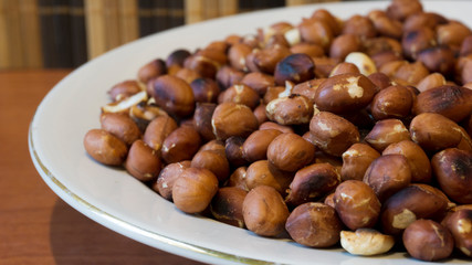 Roasted Peanuts Snack in White Plate in Wooden Backgrounds - topview ans Closeup