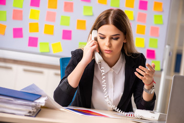 Young beautiful businesslady in conflicting priorities concept 