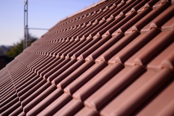 Fertige Dachdecker Bauarbeiten im Baugewerbe auf dem roten Hausdach. Hintergrund zum Dachdecken ohne Bauarbeiter im Sommer.