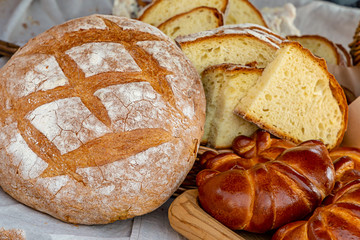 shop Baker large loaf of bread rolls with filling sliced set pieces close-up background rustic design bakery