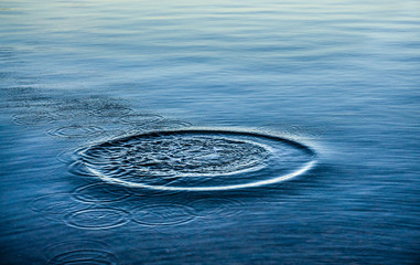 Ripples on sea texture pattern background. Round droplets of water over circles on pool water....