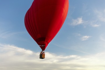 Naklejka premium Valentine's Day. Red hot air balloon in the shape of a heart fly in sky. Love, honeymoon and romantic travel concept