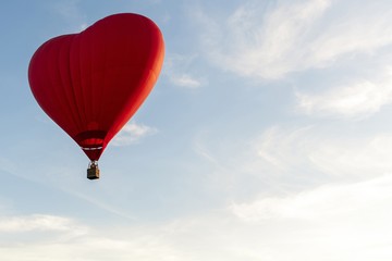 Valentine's Day. Red hot air balloon in the shape of a heart fly in sky. Love, honeymoon and romantic travel concept