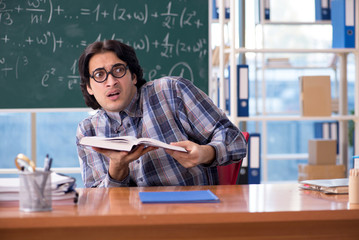 Young funny math teacher in front of chalkboard 