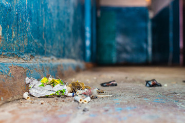 a lot of garbage on the floor in the hallway of the hostel. front and background blurred with bokeh effect