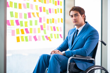 Young handsome man in wheelchair with many conflicting prioritie