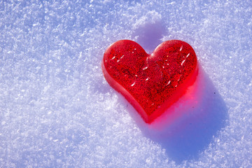 Beautiful red heart in the snow. Handmade soap in the shape of a heart. Love and Valentine's Day concept. Romantic background with free space for text.