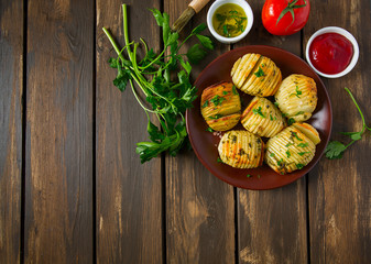Hasselback potatoes on wooden surface