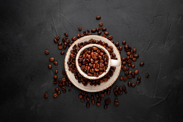 Coffee cup and beans on a concrete table