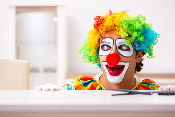 Male clown preparing for perfomance at home 