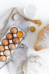 Fototapeta na wymiar Ingredients for baking homemade bread. Eggs, milk, flour. White background, top view