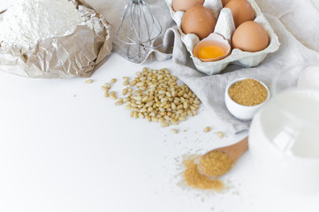 Fototapeta na wymiar Ingredients for homemade baking. Eggs, milk, flour, sugar. White background, side view