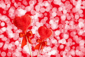Two sweet hearts with bows on sticks with abstract background