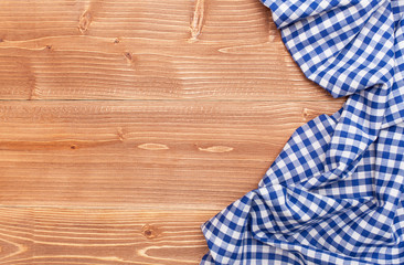  Workplace for cooking with place for text. Top view on wooden desktop, surface with blue napkin, checked fabric. Kitchen towel or textile napkin.  Can use as mock up for design