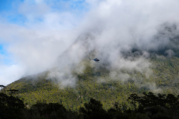 Tourist sightseeing helicopter flight over Milford Sound, Fjordland, South Island, New Zealand.