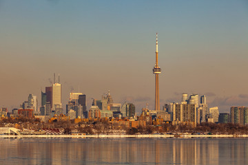 Obraz premium Toronto, CANADA - February 1th, 2019: Panoramic Canadian winter landscape near Toronto, beautiful frozen Ontario lake at sunset. Scenery with winter trees, water and blue sky.