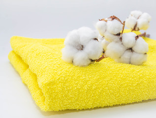 Obraz na płótnie Canvas white cotton flowers on bright yellow cotton towel close-up