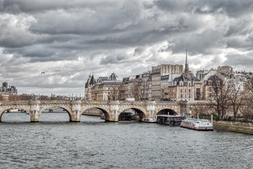Fototapeta premium Panorama of Ile de la Cite, the Conciergerie and Pont Neuf on a cloudy day in winter - Paris, France