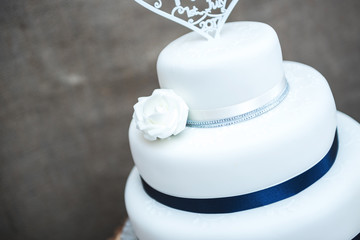 White wedding cake with ribbon design and cake topper