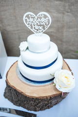 White wedding cake with ribbon design and cake topper