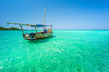 silence in emerald water and sky around alone boat in Zanzibar in Tanzania