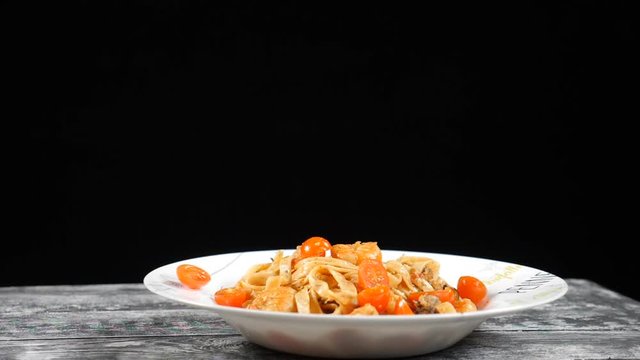 Cooking in slow motion. Cherry tomatoes falling on plate with dilicious pasta. Shot with high speed camera.Cooking concept. hd