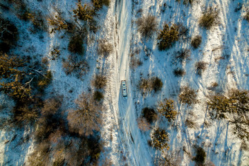 white limousine rides on a snowy road. View from above. Drone picture