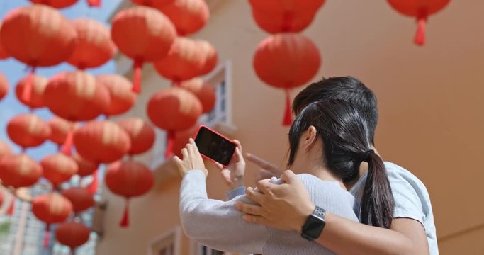 Couple use of mobile phone for take photo with red lantern