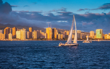 Yacht sailing at sunset in Waikiki
