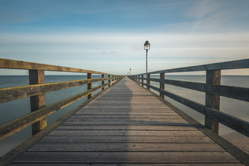 Fototapeta na wymiar Auf der Seebrücke von Lubmin am frühen Morgen bei blauen Himmel