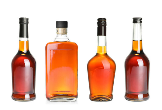 Set of bottles with expensive whiskey on white background
