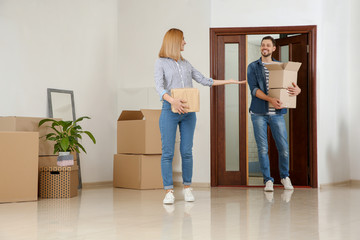 Fototapeta na wymiar Couple walking into their new house with moving boxes