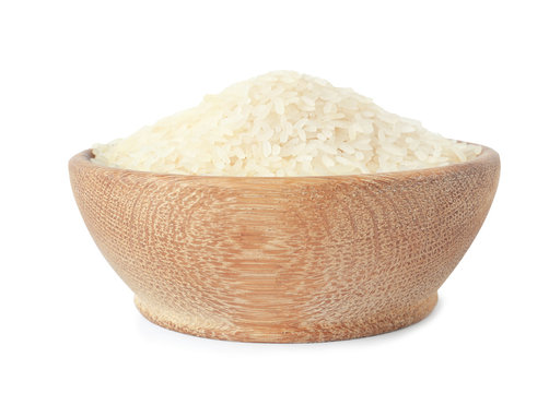 Bowl with uncooked parboiled rice on white background