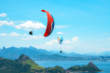 A colorful parachute with skydiver on sunny blue sky background. Active lifestyle. Extreme sport....